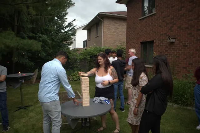 Guests playing giant Jenga at an outdoor gathering
