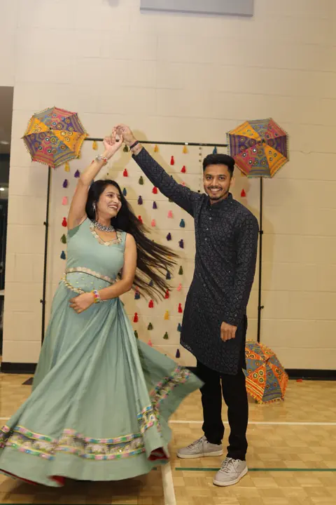 Guests sharing a dance pose at the decorated photo backdrop
