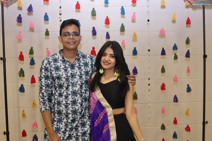 Guests smiling in front of the festive backdrop