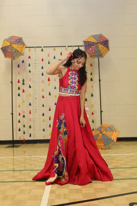 Guest posing beneath colourful Navratri decorations